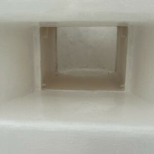 a white wall with a square hole in it